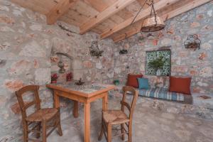 a room with a table and chairs and a couch at La Casa Di Nonna in Koríthion
