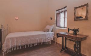 a bedroom with a bed and a sewing machine on a table at La Casa Di Nonna in Koríthion