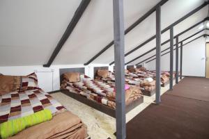 a room with four beds in a room with beams at Sheni Hostel in Tbilisi City