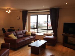 a living room with a couch and a table and a tv at BORD DE L’EAU APARTMENT in Wick