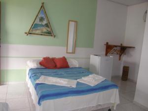 1 dormitorio con 1 cama con sábanas azules y almohadas rojas en Sol da Onda Pousada e Flats, en Barra Grande