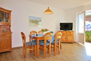 a dining room with a table and chairs and a television at Meeresblick Fehmarn Ferienhaus 42 in Fehmarn