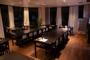 a dining room with tables and chairs and windows at La Vista Hotel Tsugaike - Stay on the Slopes in Otari