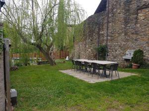einen Tisch und Stühle in einem Hof neben einer Steinmauer in der Unterkunft Salvanereta in Beuda