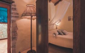 a bedroom with a bed and a floor lamp at La Casa Di Nonna in Koríthion