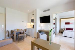 a living room with a room with a bed and a table at Hipotels Barrosa Garden in Chiclana de la Frontera