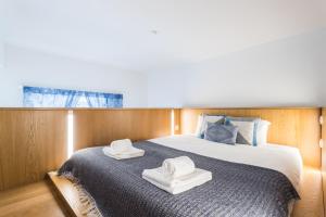リスボンにあるAlfama Blue Studio Loft Apartment - by LU Holidaysのベッド(上に白い帽子2つ付)