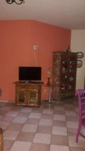 a living room with a tv and a cabinet at Recanto Pau Brasil in Sete Lagoas