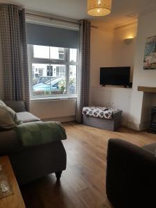 a living room with a couch and a television at Kingfisher cottage in Worthing
