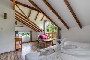 a bedroom with a bed and a desk and a chair at La Modestie Guest House in Grand'Anse Praslin