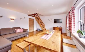 een woonkamer met een houten tafel en een bank bij Ferienwohnung zum Servus in Garmisch-Partenkirchen