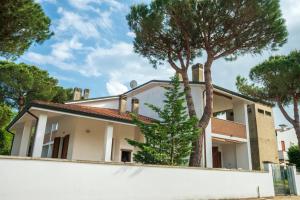 une maison avec des arbres devant elle dans l'établissement Agenzia Vear - Lido di Volano, à Lido di Volano