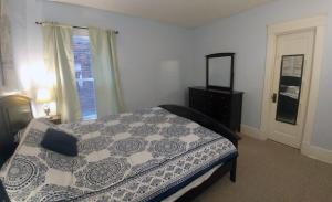 ein Schlafzimmer mit einem Bett, einer Kommode und einem Fenster in der Unterkunft Boulevard Park Apartments in Erie
