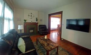 ein Wohnzimmer mit einem Ledersofa und einem TV in der Unterkunft Boulevard Park Apartments in Erie