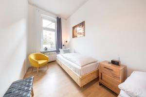 ポツダムにあるDesign Apartments - "Am Schloss"のベッドルーム1室(ベッド1台、黄色い椅子付)
