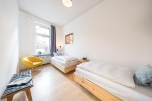 ein Schlafzimmer mit einem Bett, einem Stuhl und einem Fenster in der Unterkunft Design Apartments - "Am Schloss" in Potsdam