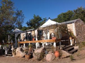 an old stone house with a porch and some plants at Chalet Valle di Corti in Pianottoli-Caldarello +19 photos