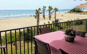 uma mesa numa varanda com vista para a praia em Paraiso frente al mar Apto duplex em Comarruga