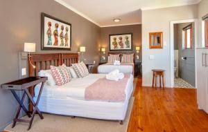 a bedroom with two beds and a table at Baleens Hotel in Hermanus