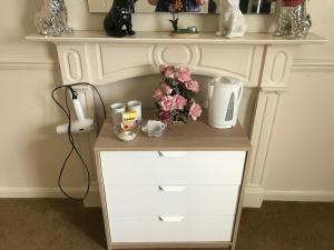 a white shelf with a table with flowers on it at Double J8 m27 in Southampton