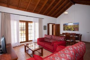 a living room with a red couch and a table at Villas & Apartamentos Tao Mazo in Lajares