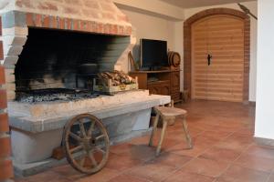 a large brick fireplace with a chair and a television at EasyLiving House near Zadar in Posedarje