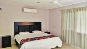 Säng eller sängar i ett rum på Hotel Kinich Ahau