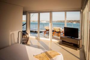 a living room with a television and a view of the ocean at Hotel Las Islas in Barú