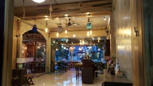 a restaurant with tables and chairs in a room at Chatchada House in Ao Nang Beach