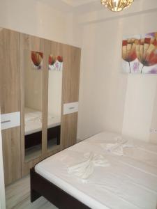 a bedroom with a white bed and a mirror at Hotel Dioni in Paralia Katerinis