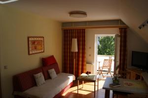 ein Wohnzimmer mit einem Sofa und einem TV in der Unterkunft Ferienwohnungen Ostsee & Mehr in Heringsdorf