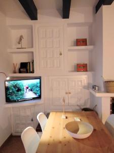 a dining room with a table and a tv on a wall at Paraiso frente al mar Apto duplex in Comarruga