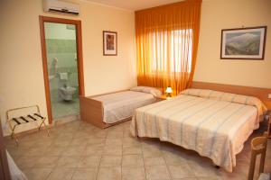 a hotel room with two beds and a bathroom at Caffè Nuovo 2 Holiday Rooms in Trappitello