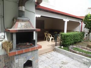 eine Terrasse mit einem Backofen im Freien in einem Haus in der Unterkunft Hotel Dioni in Paralia Katerinis