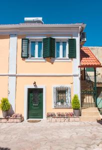 una casa con una porta verde e persiane verdi di Spiti Lagis a Chlomatianá
