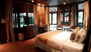 Highland Resort & Nature Tours في Tomohon: غرفة نوم بسرير وتلفزيون ونوافذ