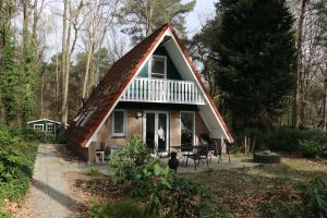 een klein huis met een gambrel dak bij Calluna151 in Harfsen