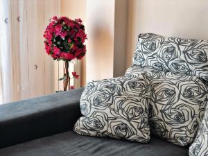 a bed with black and white sheets and a vase of flowers at Apartamento Montolieu Sanxenxo in Sanxenxo
