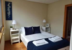 a bedroom with a bed with towels on it at Cosy Santa Catarina Flat in Porto
