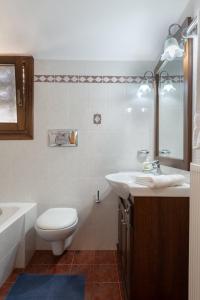 a bathroom with a toilet and a sink and a tub at Katerina's Cozy Mountain View Apartment in Argostoli