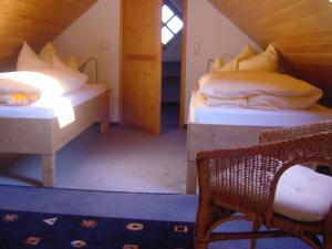 Zimmer mit 2 Betten, einem Tisch und einem Stuhl in der Unterkunft Ferienwohnung Wolfersdorf in Wolfersdorf