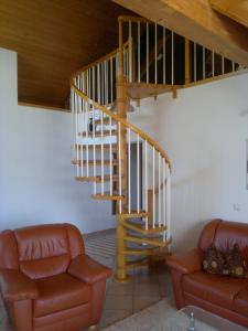 eine Treppe in einem Wohnzimmer mit Sofa und Treppenaufgang in der Unterkunft Ferienwohnung Wolfersdorf in Wolfersdorf