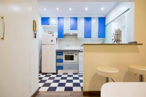 a kitchen with blue cabinets and a checkered floor at Nice 2 bedrooms Madrid downtown in Madrid