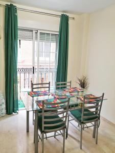 uma sala de jantar com uma mesa de vidro e cadeiras em Súper céntrico, luminoso, amplio, terrazas y patio em Alicante