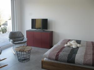a bedroom with a bed and a chair and a television at Traumblick Vallendar in Vallendar