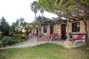 une maison avec des chaises roses sur une terrasse dans l'établissement Quinta do Mar - Country & Sea Village, à Luz