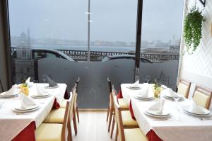 un restaurante con mesas y sillas blancas y vistas en Hotel Cristal 2, en A Coruña