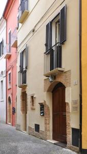 a building with a door and balconies on a street at Antica Interamnia in Teramo