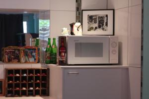 Un four micro-ondes est installé au-dessus d'un réfrigérateur. dans l'établissement De Buitenmuur Guest House, à Turnhout