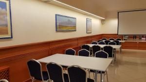 sala konferencyjna ze stołami i krzesłami oraz ekranem w obiekcie Hotel Korona w Słubicach